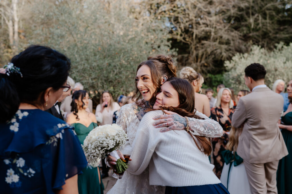 Wedding guests laughing and enjoying the autumn wedding at Shustoke Barn.