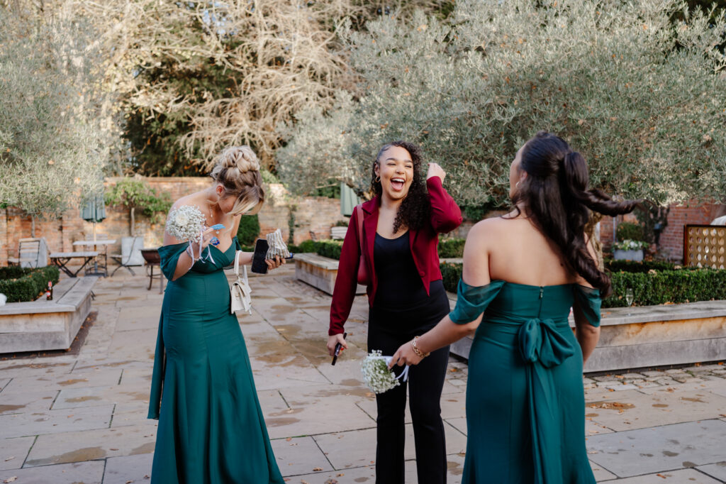 Bridesmaids laughing together during wedding celebrations at Shustoke Barn.